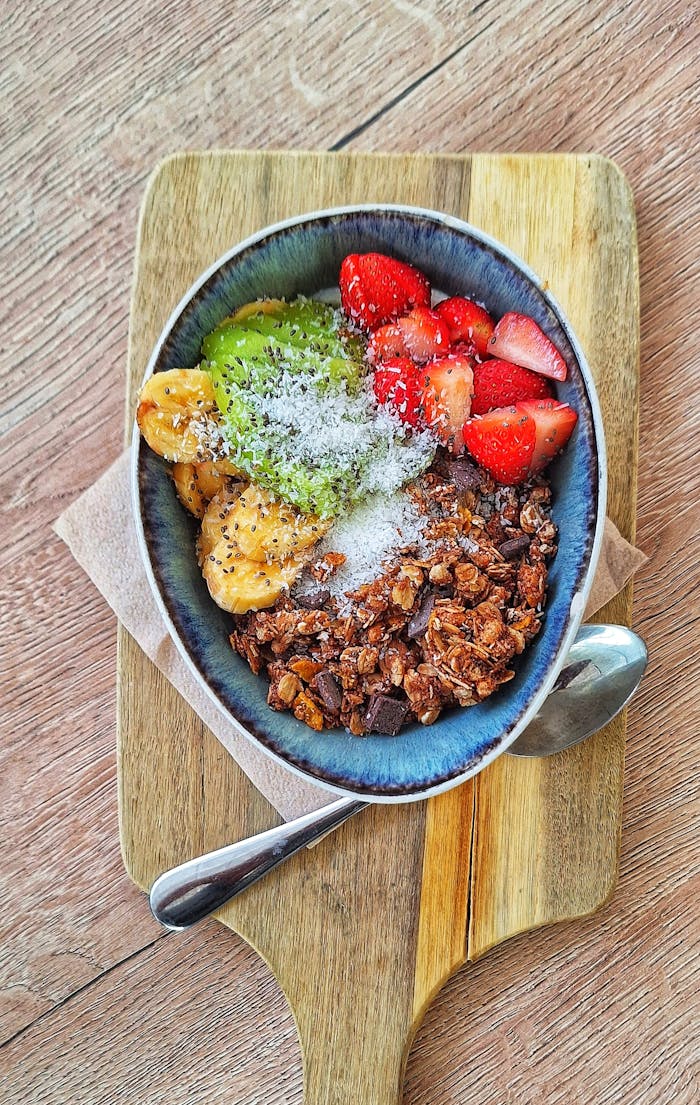The Art of Drawing Readers In: Your attractive post title goes here Delicious fruit and granola bowl with coconut on wooden board, perfect for a fresh start.