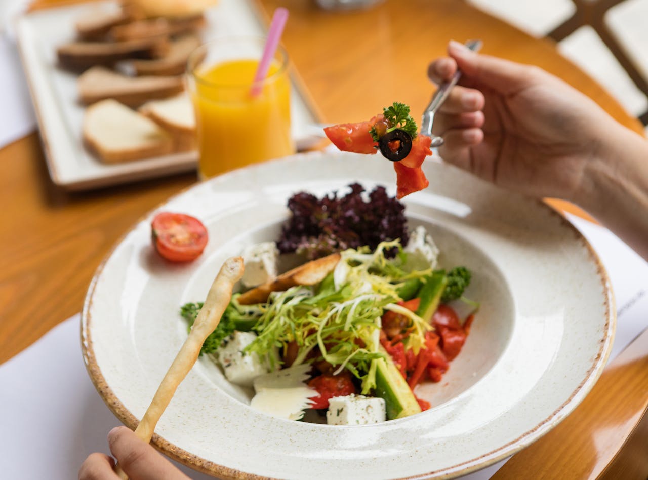 services-02 A fresh Greek salad with feta cheese and vegetables on a sunny day.